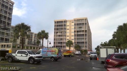 View of apartment building / complex featuring uncovered parking