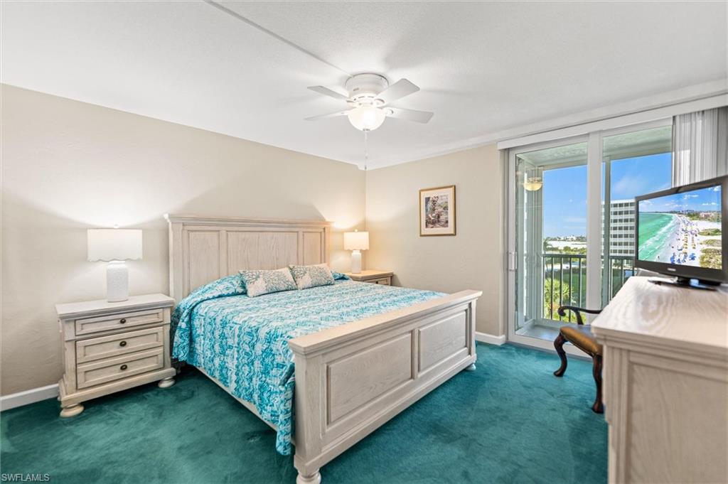 Bedroom featuring dark colored carpet, access to outside, and ceiling fan