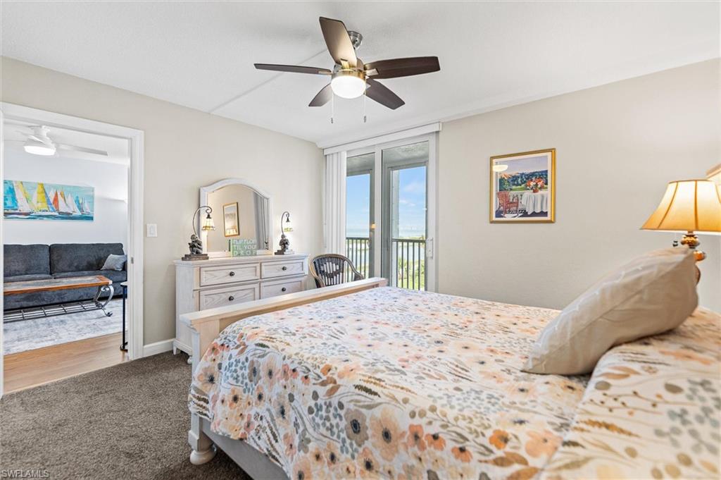 Bedroom featuring access to outside, dark colored carpet, and a ceiling fan