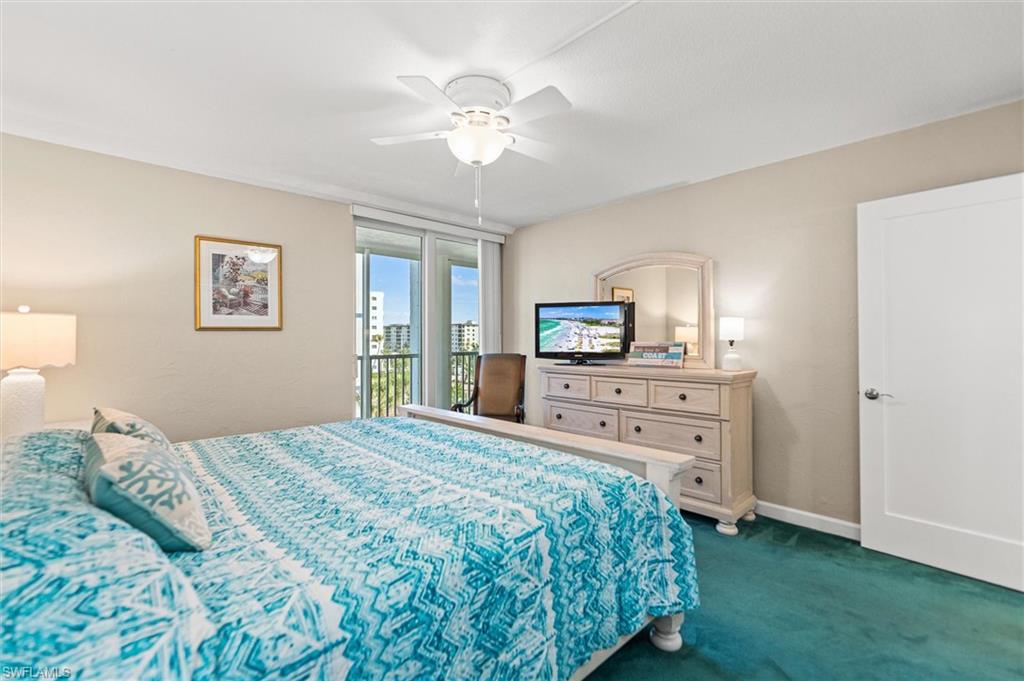 Bedroom with access to outside, dark colored carpet, and ceiling fan