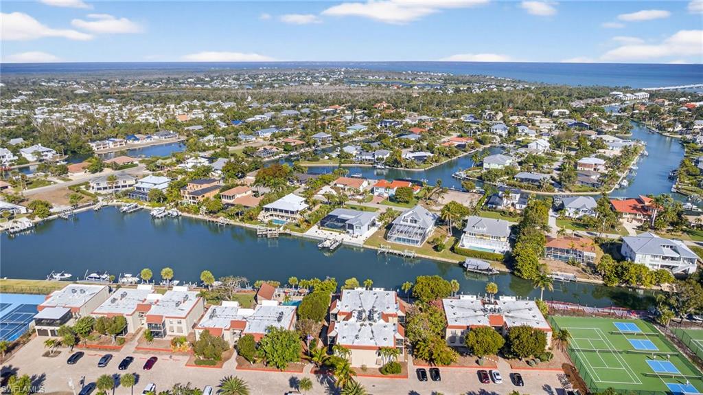 Aerial view of property's location featuring a nearby body of water and nearby suburban area