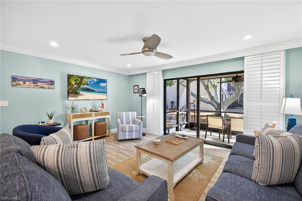 Living room with ceiling fan, wood finished floors, recessed lighting, and ornamental molding