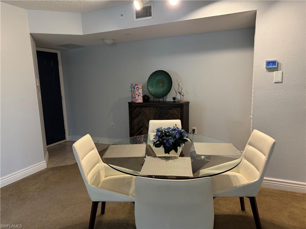 Dining space with carpet floors and a textured ceiling
