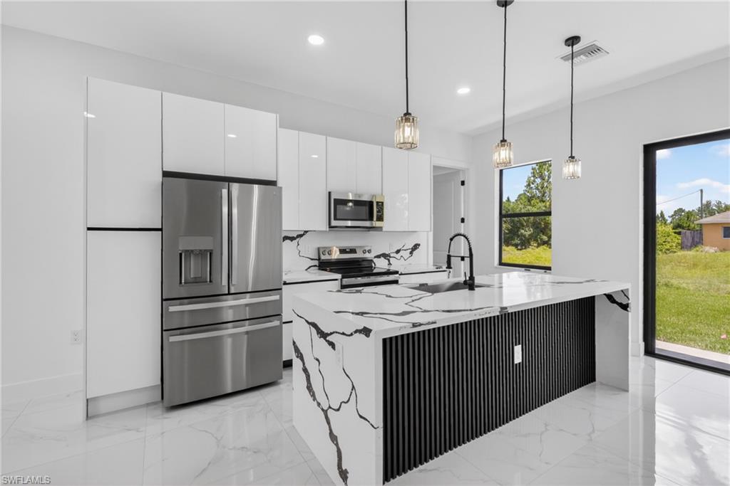 Contemporary kitchen featuring a waterfall island with a slatted black panel base, complemented by matching countertops and backsplash