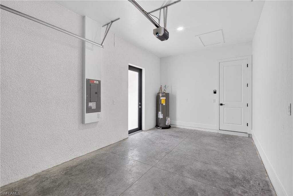 Garage space featuring textured white walls, a concrete floor, and an overhead garage door opener
