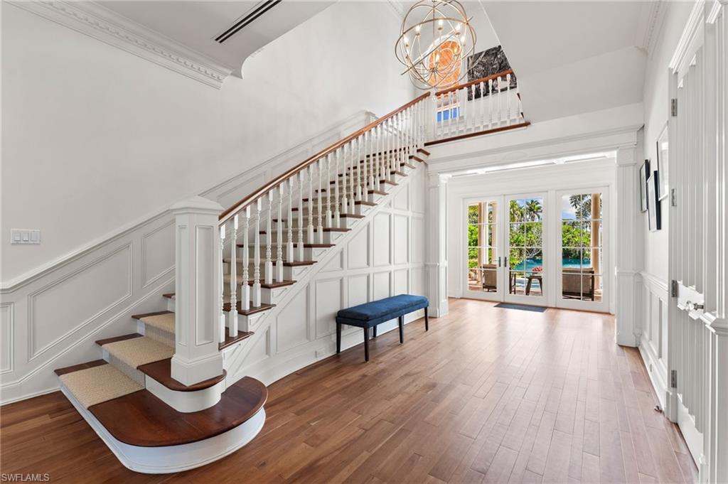 Foyer with a decorative wall, wood finished floors, and stairway