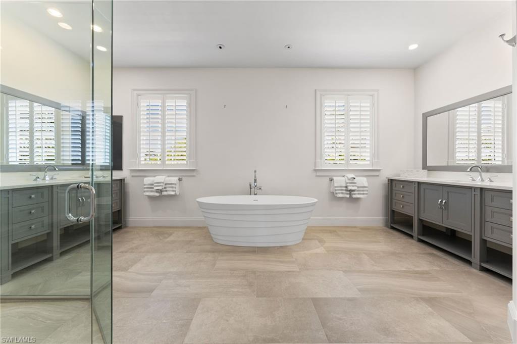 Bathroom with a soaking tub, a shower stall, vanity, recessed lighting, and baseboards
