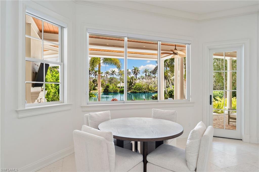 Dining room with a water view, baseboards, and crown molding