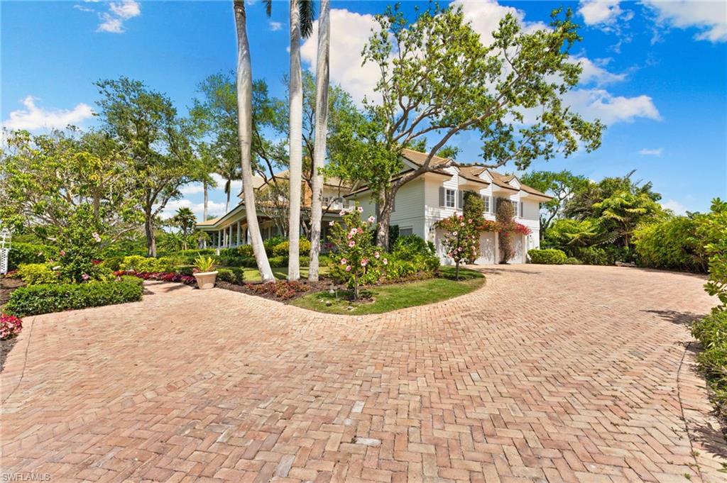 View of side of home with curved driveway and a garage