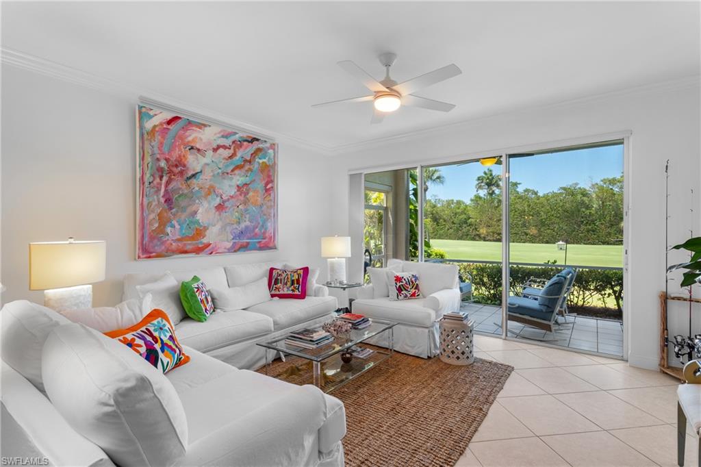 Living area featuring light tile patterned floors, ornamental molding, and ceiling fan