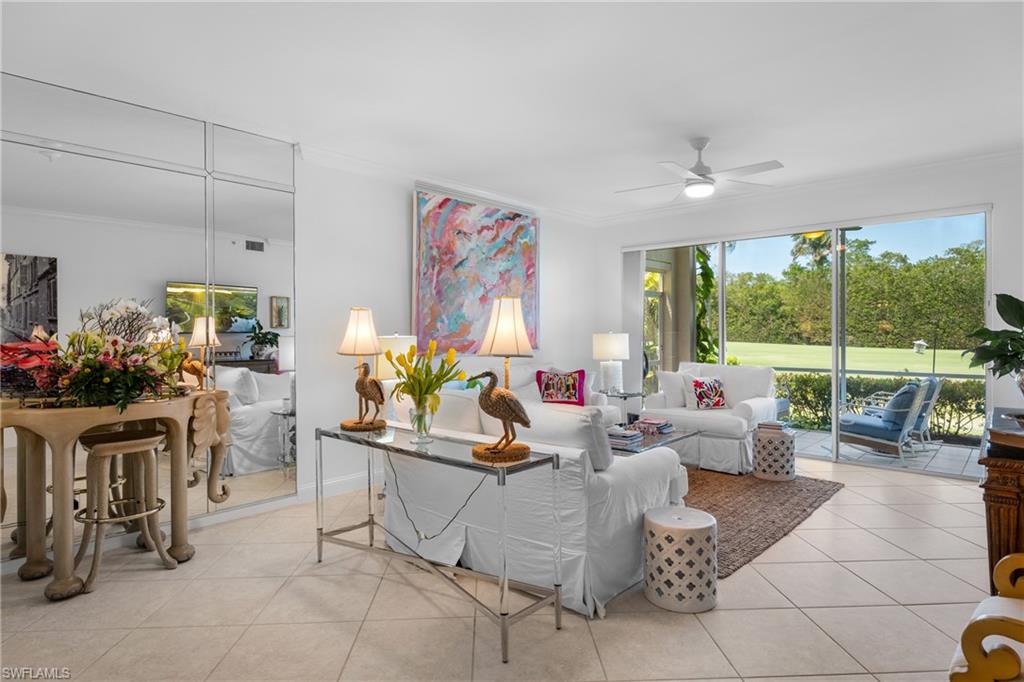 Tiled living area featuring crown molding and a ceiling fan