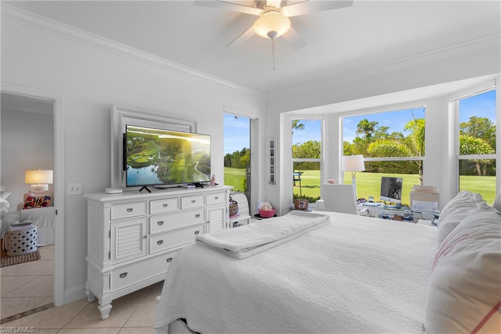 Bedroom featuring ornamental molding, light tile patterned floors, and a ceiling fan