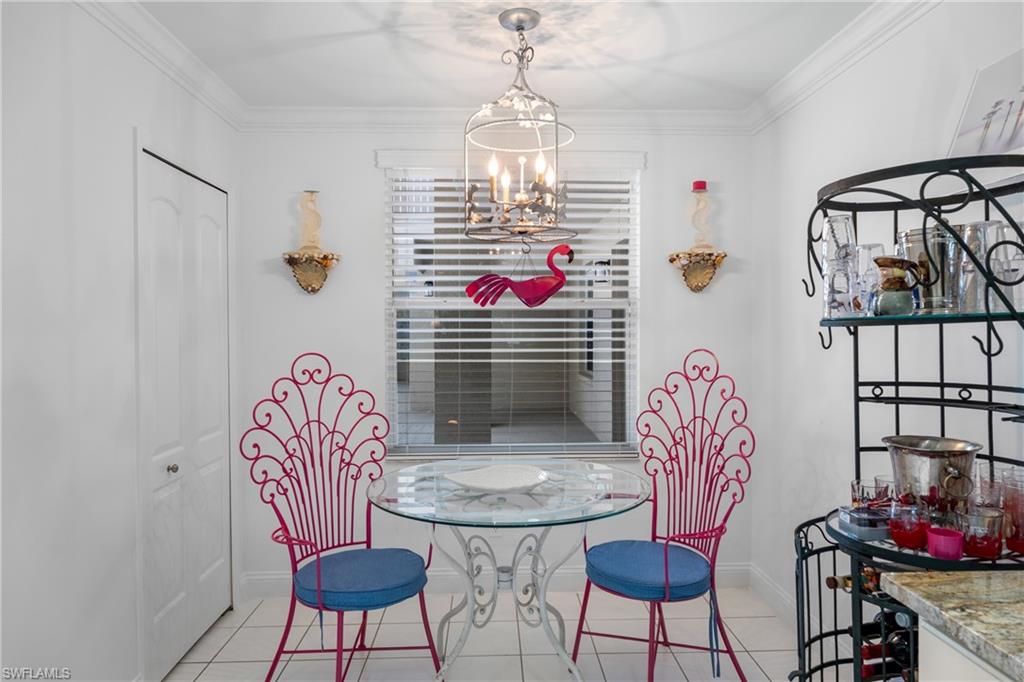 Dining area featuring a chandelier, light tile patterned floors, baseboards, and ornamental molding
