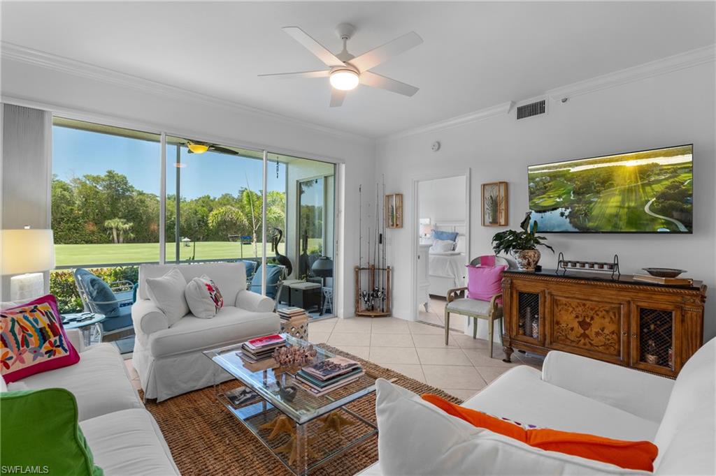 Living room featuring ornamental molding, visible vents, a ceiling fan, and light tile patterned floors