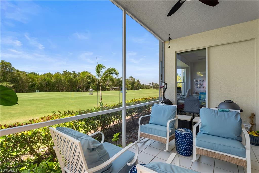 Sunroom with ceiling fan and golf course view