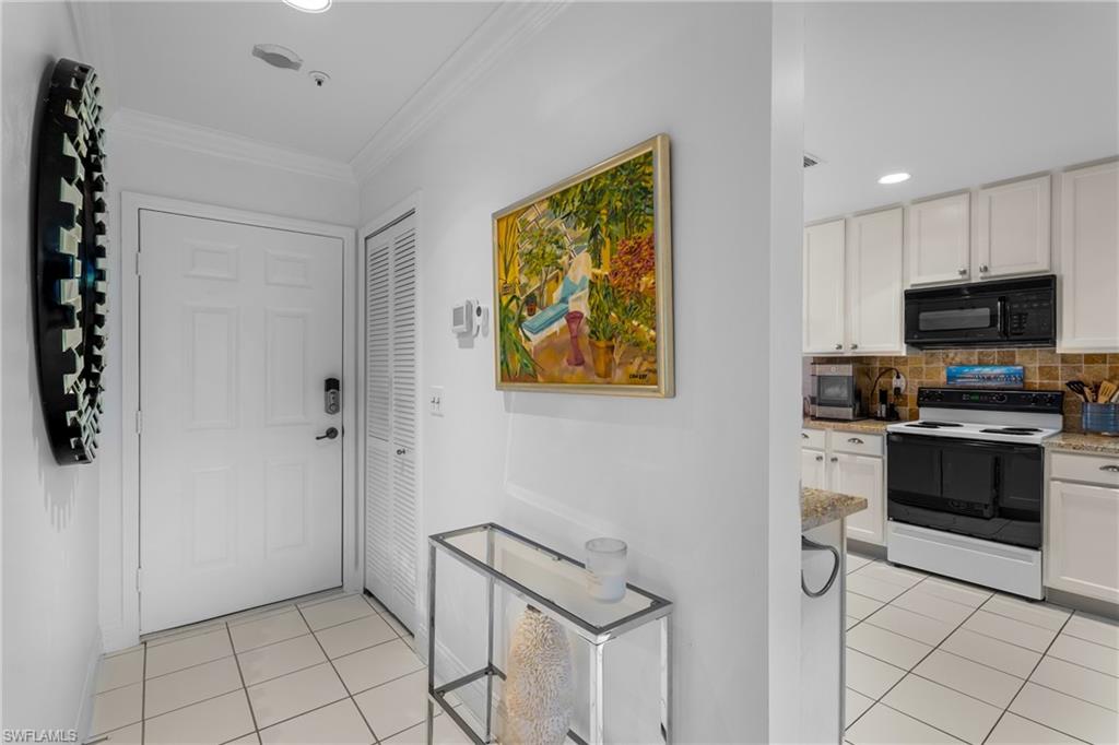 Entryway with recessed lighting, light tile patterned floors, and crown molding
