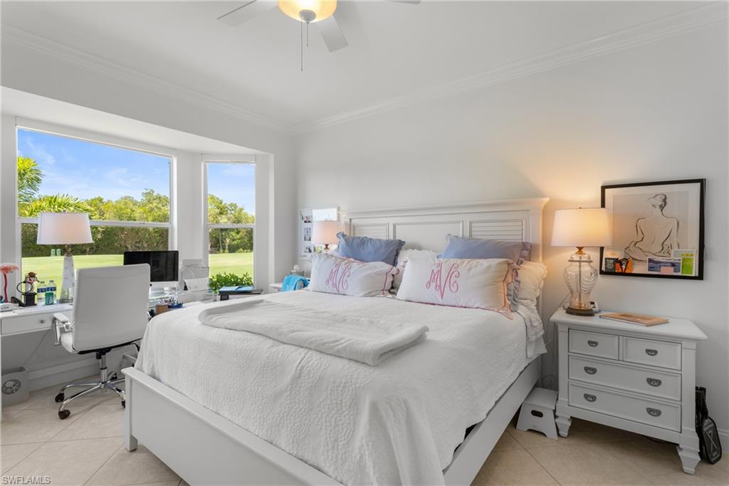 Bedroom with ornamental molding, light tile patterned floors, and ceiling fan