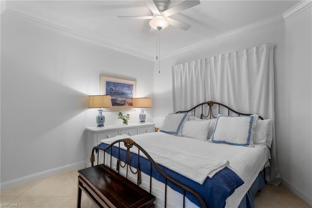 Bedroom with ornamental molding, baseboards, ceiling fan, and light tile patterned floors