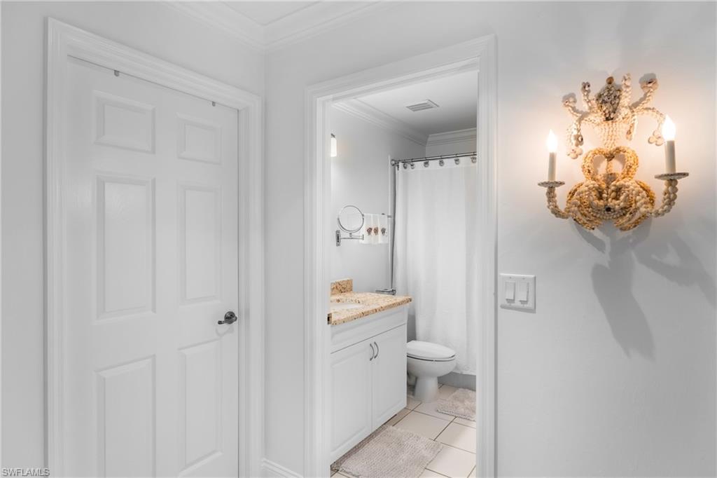 Bathroom featuring vanity, ornamental molding, tile patterned floors, toilet, and visible vents