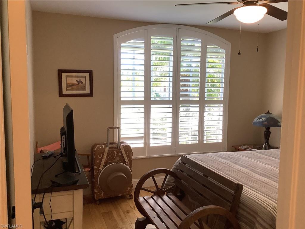 Guest bedroom w/ beautiful arch window and plantation shutters