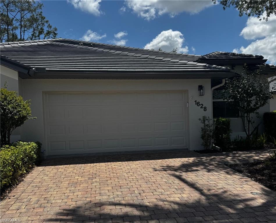 Garage featuring decorative driveway