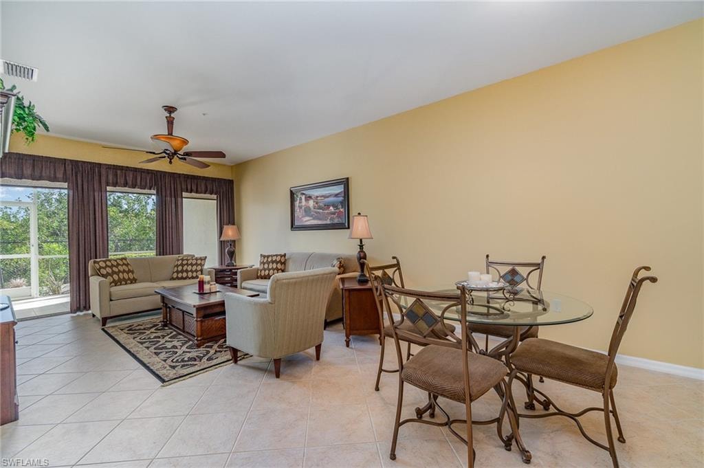 Living room with ceiling fan and light tile patterned flooring