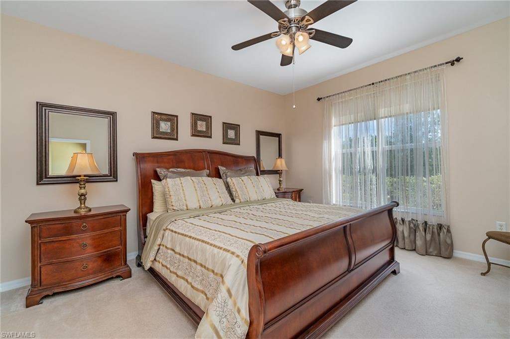 Bedroom with ceiling fan and light colored carpet