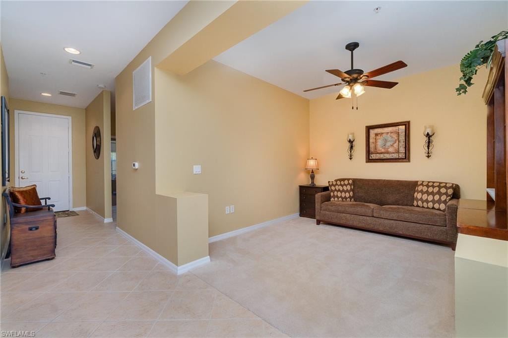 Carpeted living room with ceiling fan
