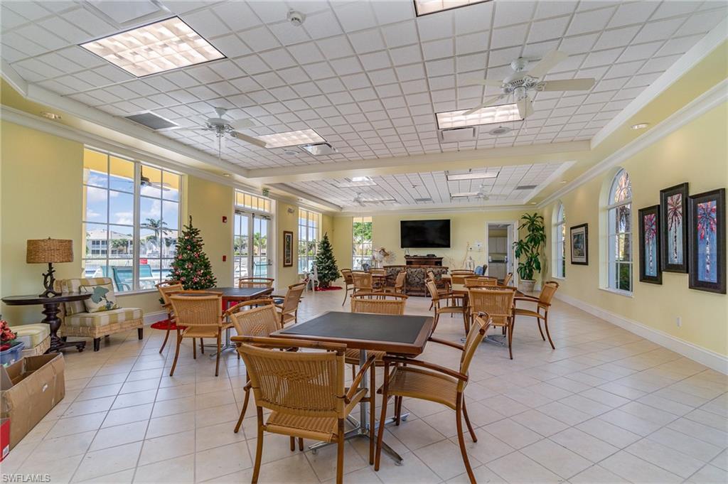 Tiled dining room featuring ceiling fan and crown molding