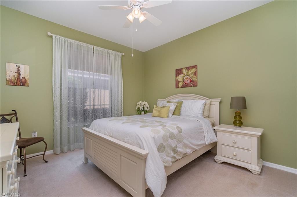 Bedroom with ceiling fan and light carpet