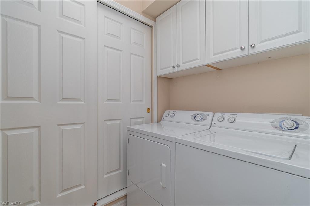 Washroom with cabinets and washer and dryer