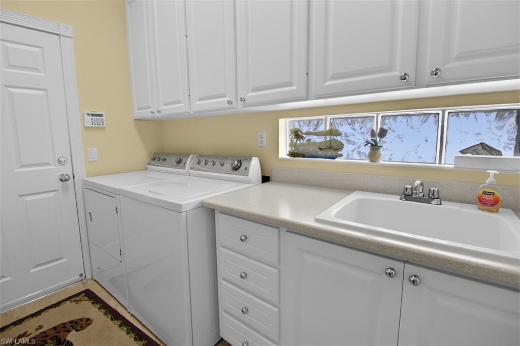 Laundry area featuring washer and clothes dryer and cabinet space