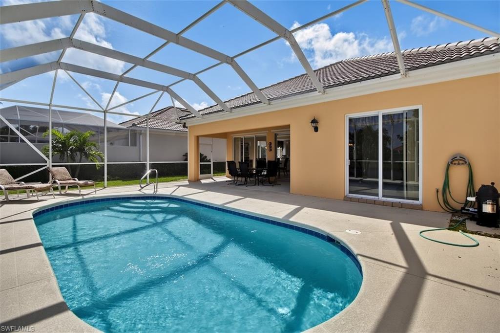 Fully screened-in outdoor pool with outdoor dining space, a patio area, a sunroom, and