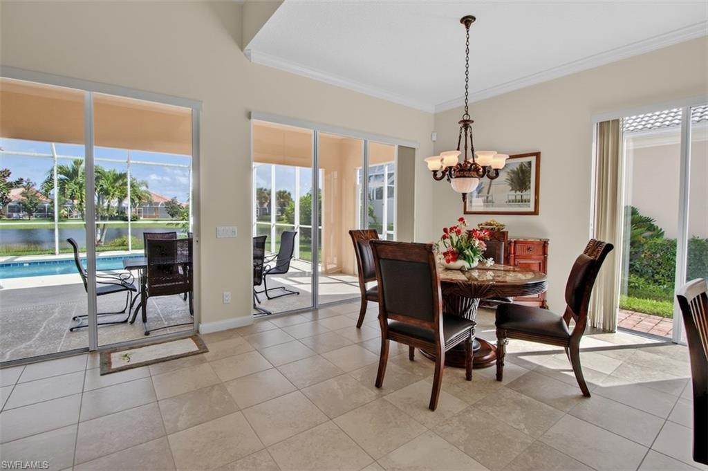 Dining area featuring crown molding, suspended lighting, healthy amount of natural light, and light tile patterned flooring