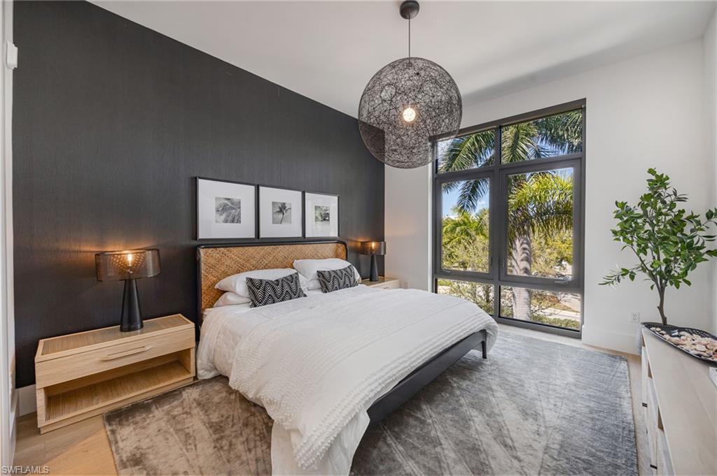 Bedroom with an accent wall and wood finished floors