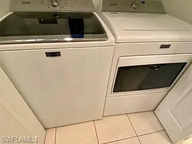 Laundry area featuring washing machine and dryer and tile patterned flooring