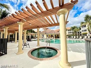 Community pool with a community hot tub, a patio area, and a pergola