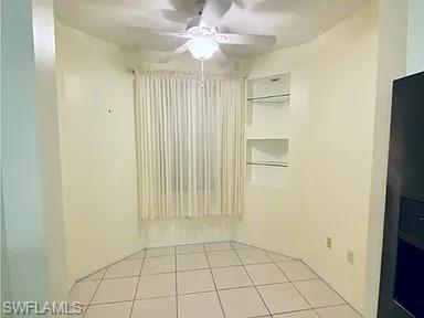 Unfurnished room featuring ceiling fan and light tile patterned flooring