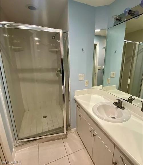 Bathroom with vanity, light tile patterned flooring, and a shower stall