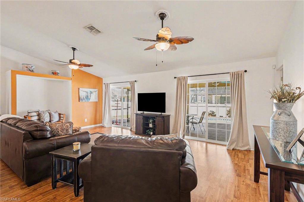 Living area featuring light wood-type flooring, a ceiling fan, and lofted ceiling