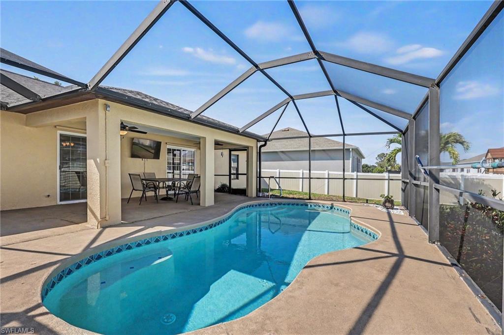 View of pool featuring outdoor dining space, a sunroom, a lanai, and patio surround