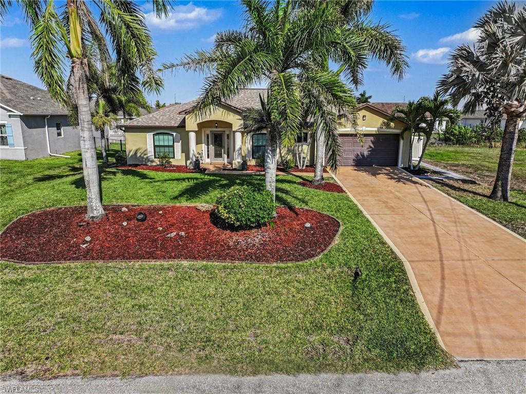 View of front of house with stucco siding, concrete driveway, an attached garage, and a front yard