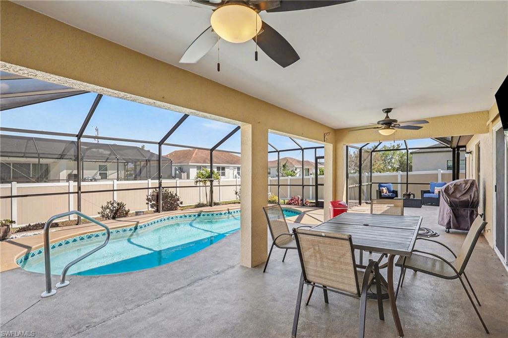 View of pool with patio surround, a fenced backyard and outdoor dining area