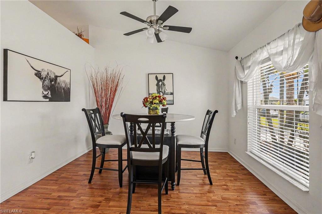 Dining space featuring wood finished floors, lofted ceiling, and ceiling fan