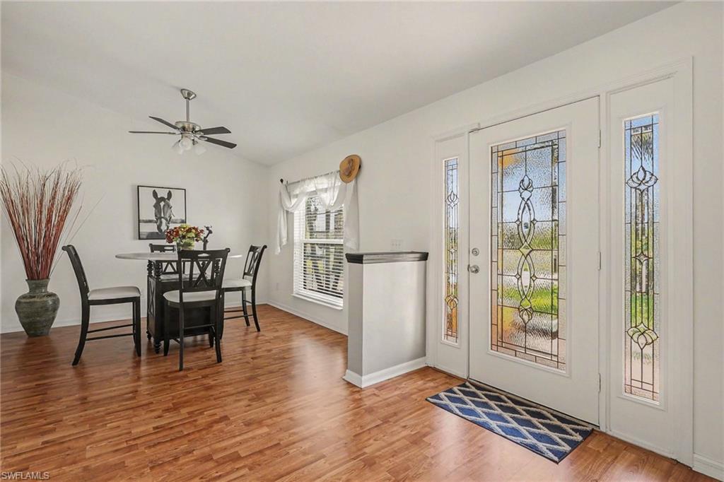 Foyer featuring a ceiling fan, vaulted ceiling, and wood finished floors