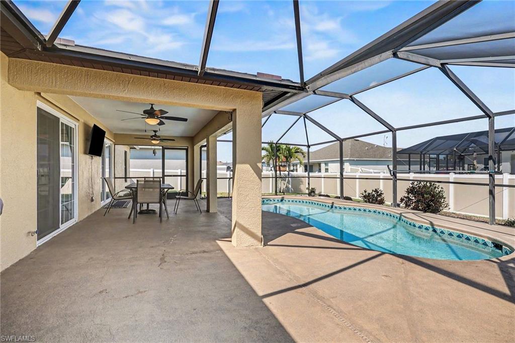 Swimming pool featuring glass enclosure, outdoor dining space, a patio, and a sunroom