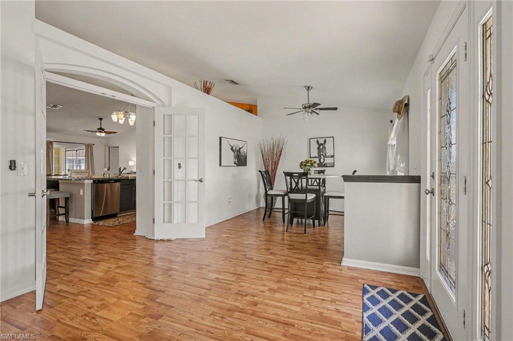 Entryway featuring ceiling fan, light wood-style floors, and vaulted ceiling