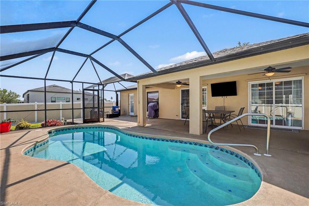 View of pool featuring an outdoor dining space, patio surround, and a lanai