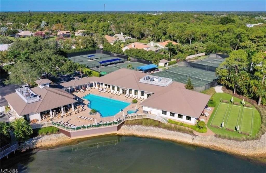 Aerial view of a pool area and a large body of water