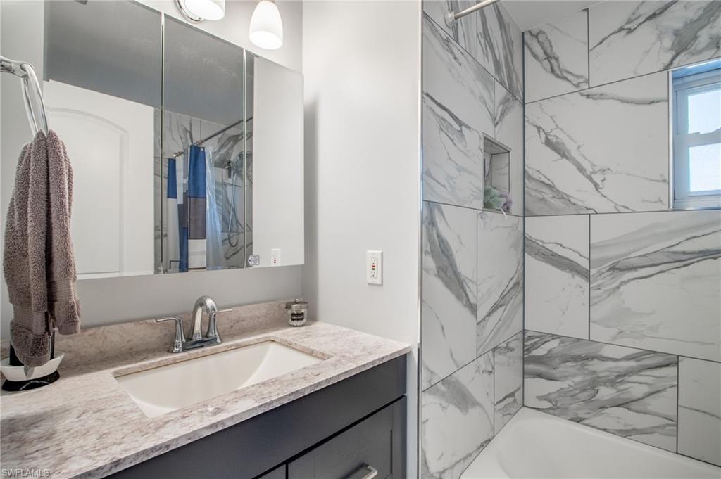 Bathroom featuring vanity and shower / tub combo with curtain